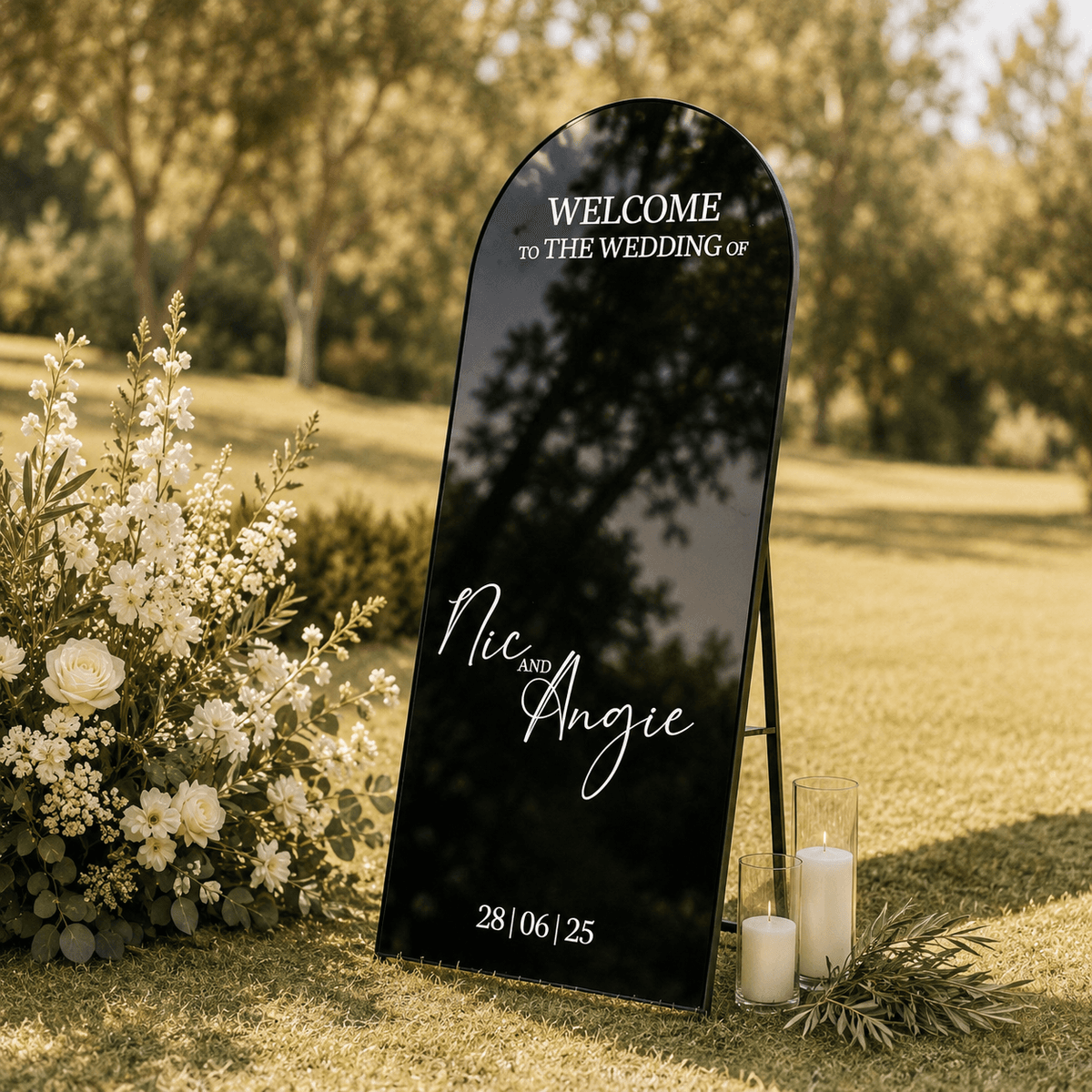 Black arched welcome sign in a garden for Nic & Angie